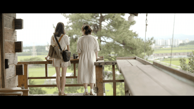 Backs of two women enjoying view from balcony