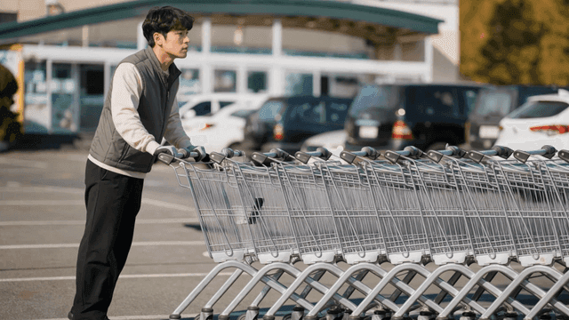 Man organizing shopping carts in parking lot