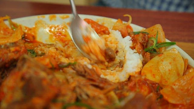 매콤한 뼈찜 양념에 밥을 비비는 장면