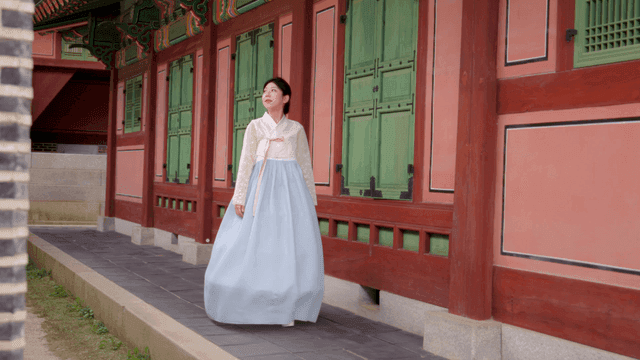 전통 건축물을 감상하는 한복 입은 여성
