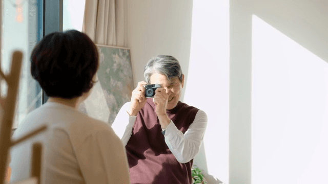 Elderly man smiling and taking a photo