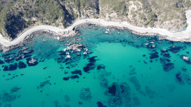 Coastal road winding along the clear sea
