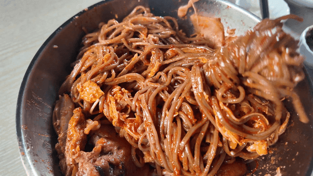 Chopsticks for rolling spicy bibim guksu in bowl