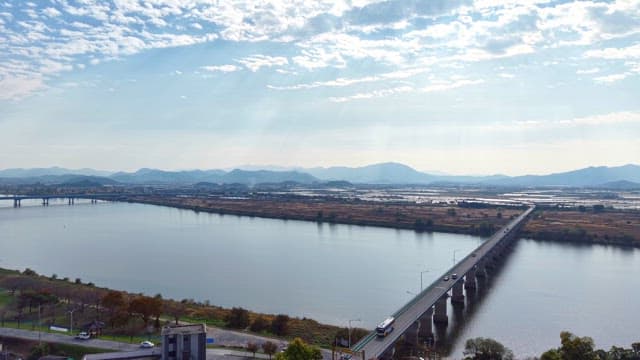 Serene river with a bridge and distant mountains