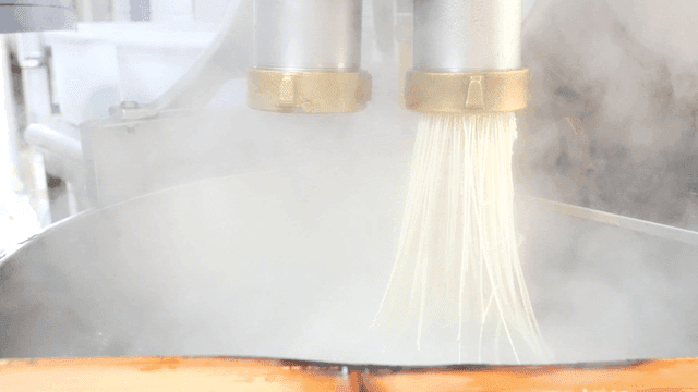 Extrude noodles into steaming pot