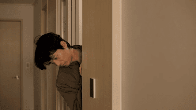 문 뒤에서 얼굴을 내민 남자