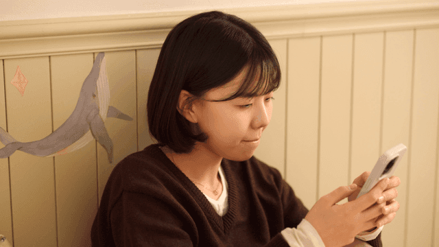 Young woman using smartphone in room