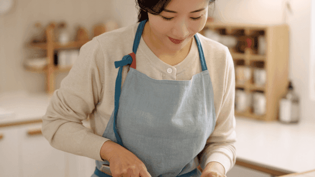 Woman chopping tofu in a kitchen