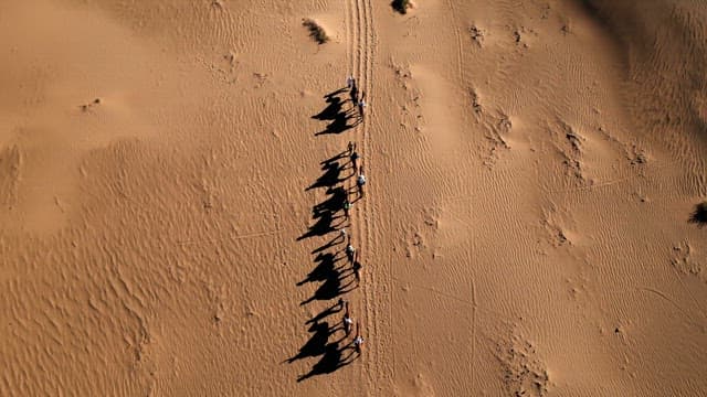 사막에서 낙타를 타는 사람들