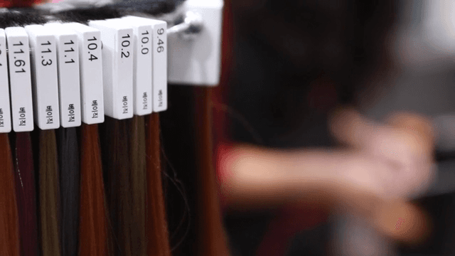 Hairdresser and various hair color samples on display