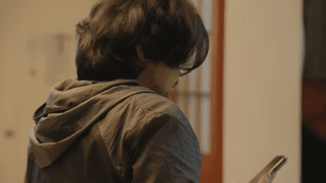 Man lost in thought while looking at his smartphone