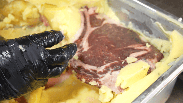Chef taking out butter-wrapped steak