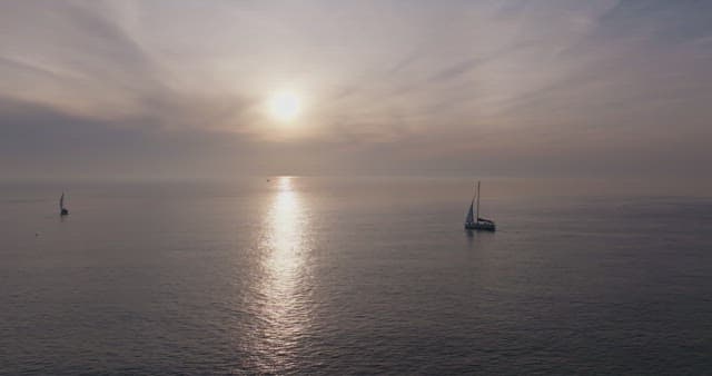 Yacht sailing on a calm sea at sunset