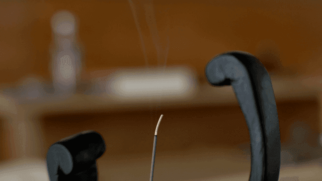 나무 조각품 사이 연기가 나는 향