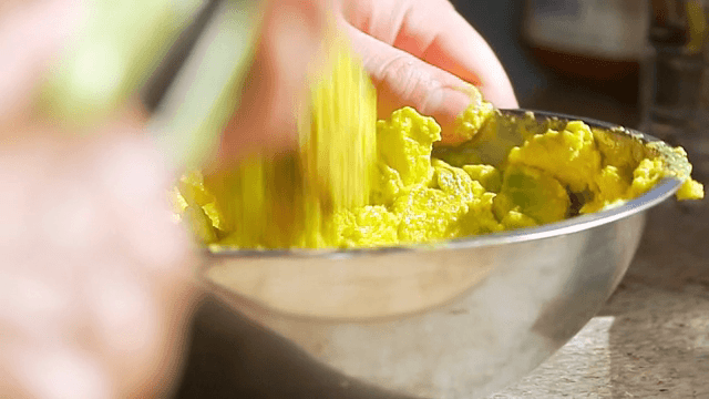 금속 그릇에서 아보카도를 으깨는 손