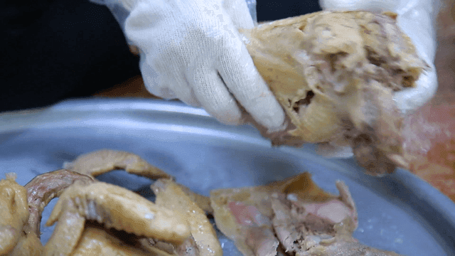 손으로 닭고기를 손질하는 사람