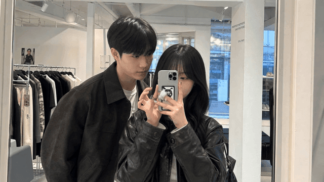 Couple taking mirror selfie in clothing store