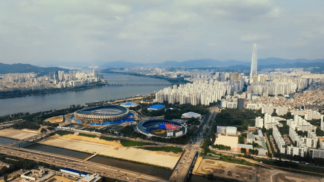 A sprawling cityscape with a river and stadiums