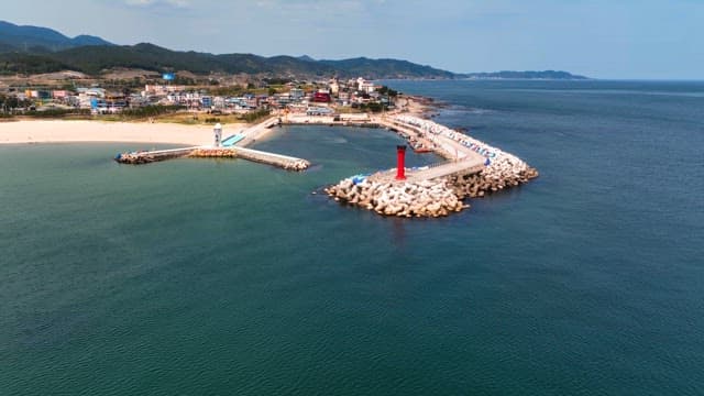 Coastal village with a lighthouse and breakwater