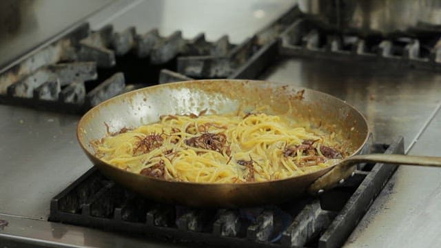 Pasta being cooked in a pan on a stove