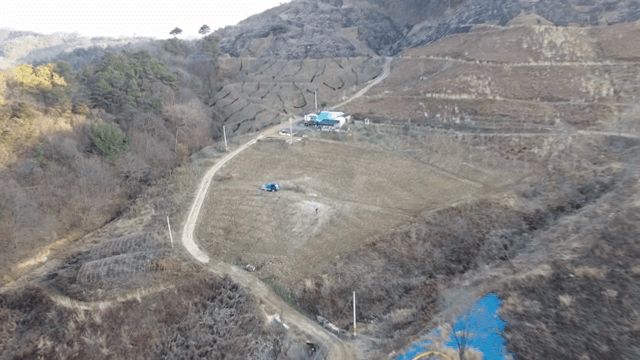 언덕과 나무로 둘러싸인 시골 농장