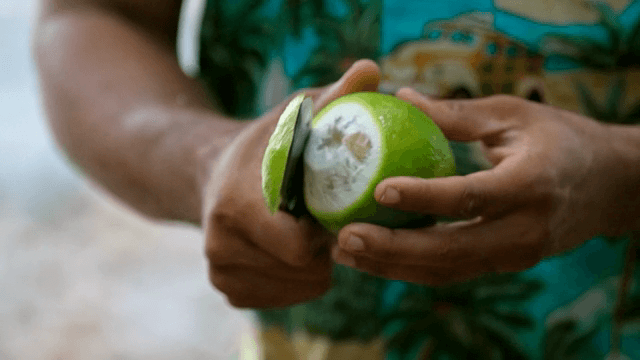 신선한 녹색 과일을 껍질 벗기는 사람