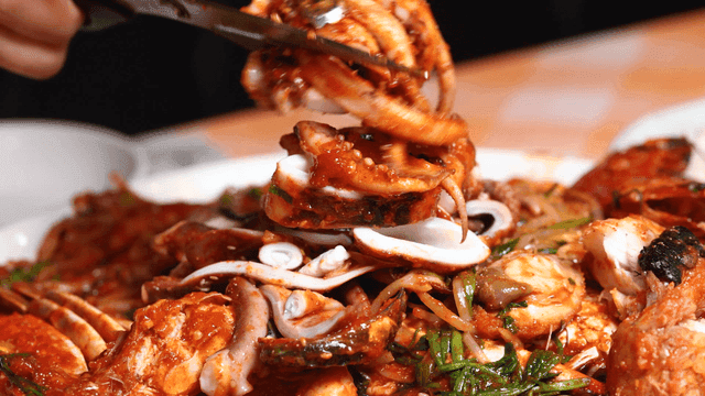 Spicy squid seafood stew cut with scissors