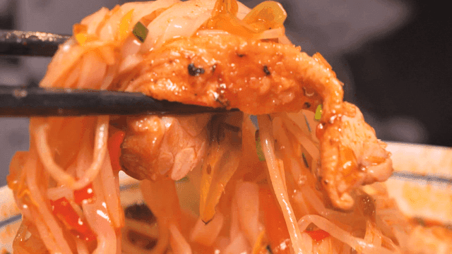 Bowl of spicy rice noodles eaten with chopsticks