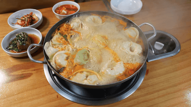 Steaming pot of dumpling stew with side dishes
