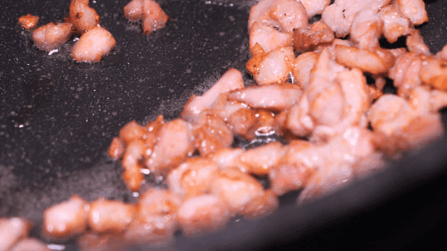 Sizzling pieces of meat in pan