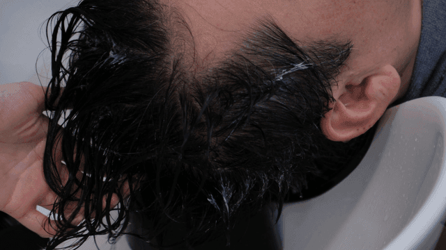 Hairdresser performing hair treatment at beauty salon