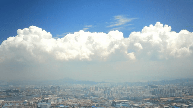 Cityscape under a vast blue sky with clouds