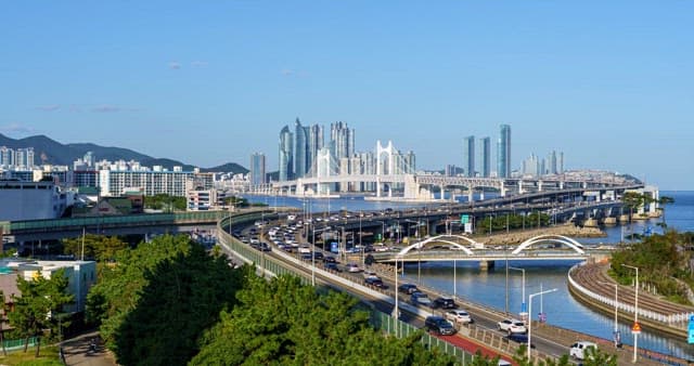 고층 빌딩과 다리가 보이는 번잡한 항구 도시의 낮부터 밤까지의 풍경