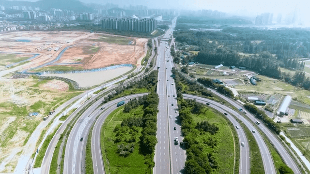Highway surrounded by greenery and cityscape