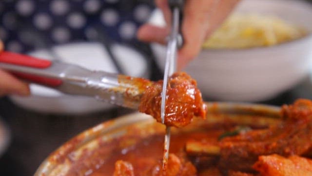 Cutting the meat of the spicy braised ribs boiling