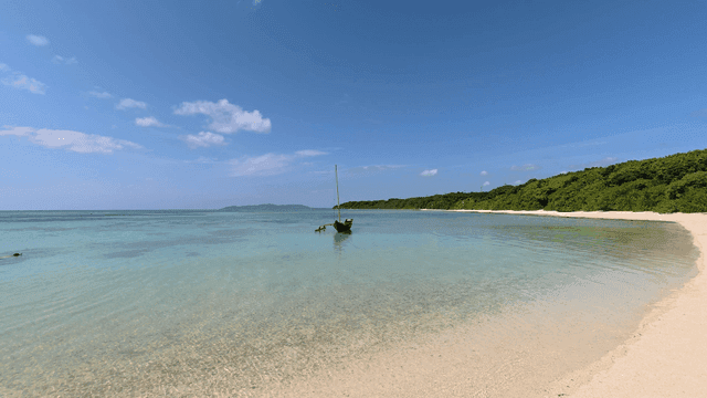 Quiet beach with small wooden boat