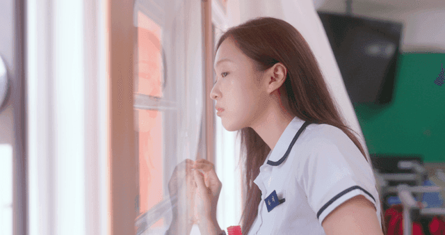 Schoolgirl waving through a window