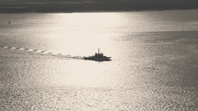 햇빛이 비치는 바다 위를 항해하는 배