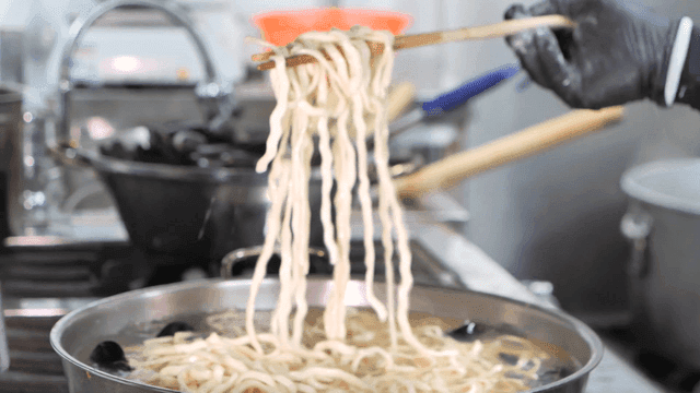 Kalguksu picked up with chopsticks in kitchen