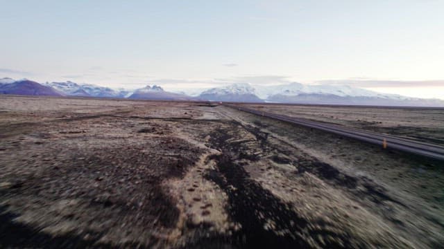 Car driving through a vast mountain landscape