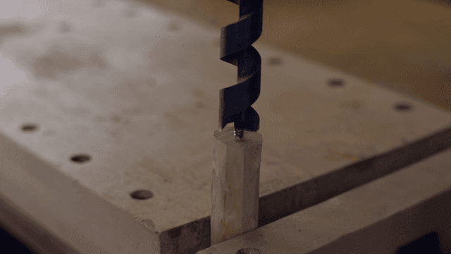Drill bit penetrating a wooden block