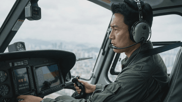 Pilot operating a helicopter over a city