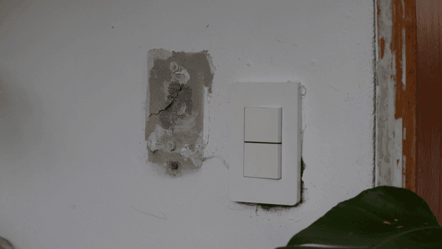 Light switch on white concrete wall