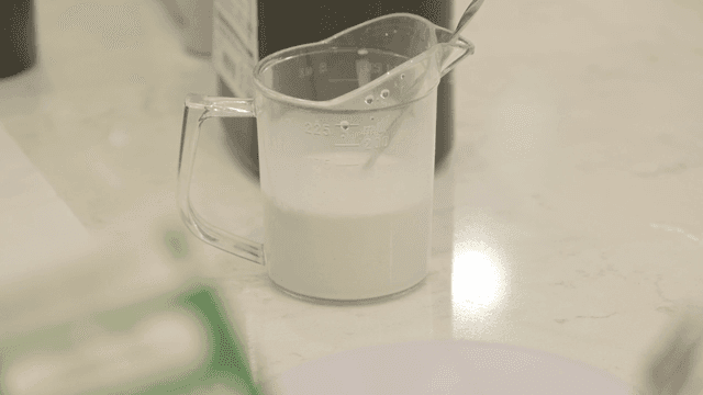 Measuring cup with milk on a kitchen counter