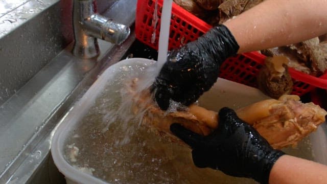 Rinsing boiled pig's feet and meat in water in the kitchen