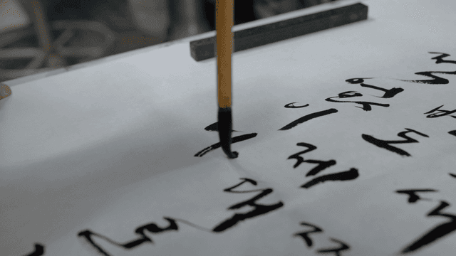 Hands writing traditional Korean calligraphy