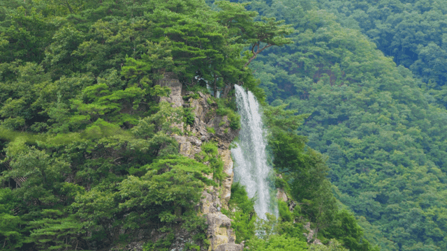 푸른 산속 절벽을 따라 흐르는 폭포