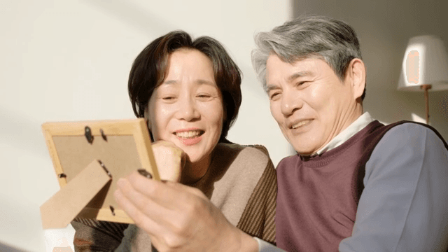 Elderly couple looking at a photo frame