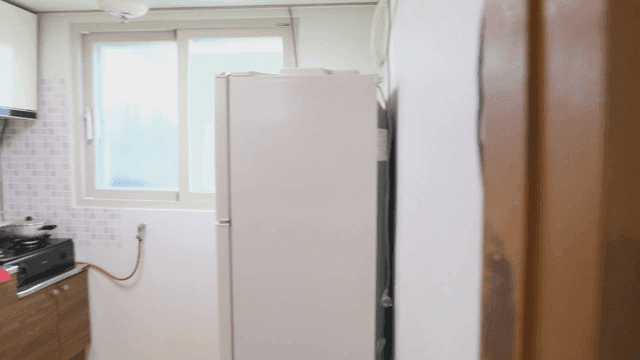 시계와 TV가 있는 깔끔한 방과 부엌