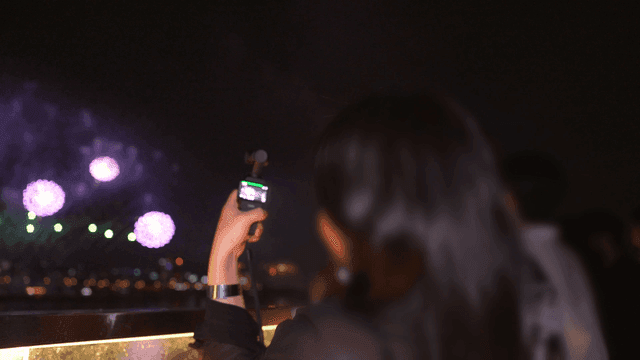 Person taking pictures of night fireworks